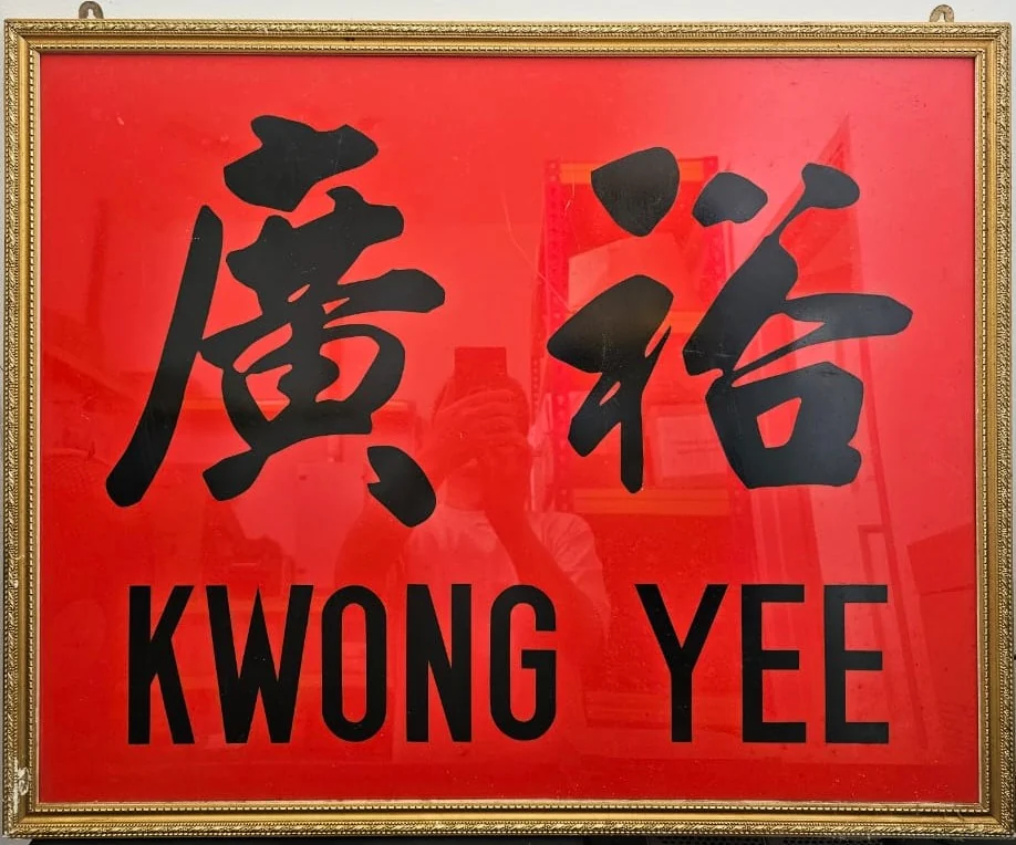 The original family business signboard bearing Kwong Yee and the Chinese characters Guang Yu